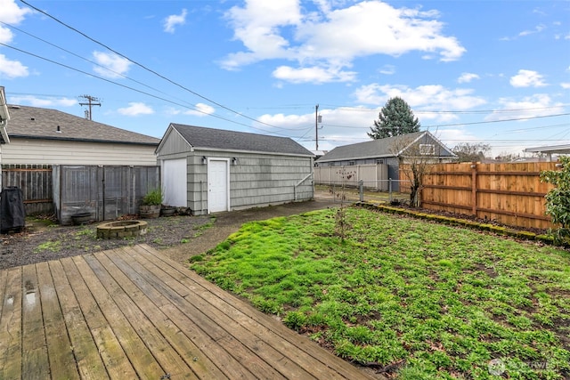 view of yard with a storage shed, an outdoor structure, a fenced backyard, and a fire pit