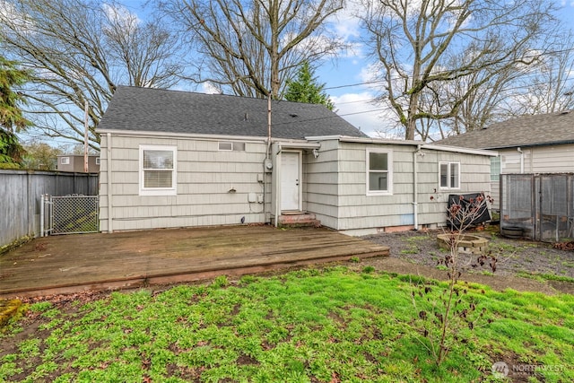 rear view of house featuring crawl space, fence, roof with shingles, and a wooden deck