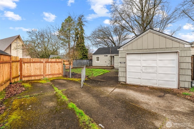 detached garage with driveway and fence