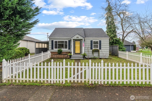 bungalow-style house with a fenced front yard, a front yard, and roof with shingles