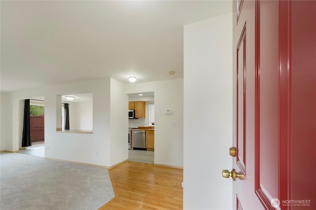 interior space featuring baseboards and light wood finished floors