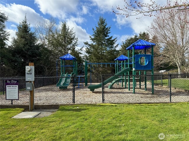 community play area featuring a lawn and fence