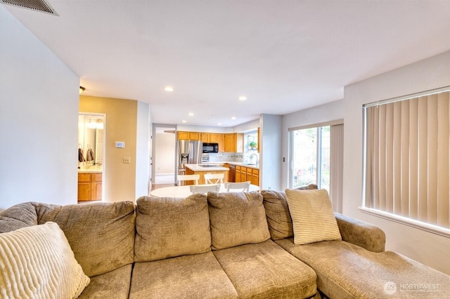 living area featuring recessed lighting and visible vents