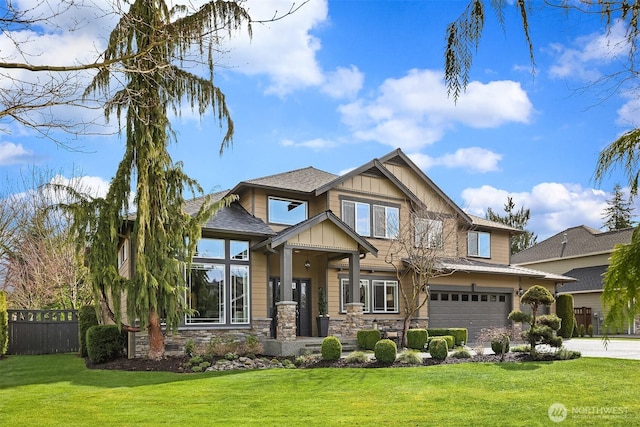 craftsman house featuring fence, a front lawn, a garage, stone siding, and board and batten siding