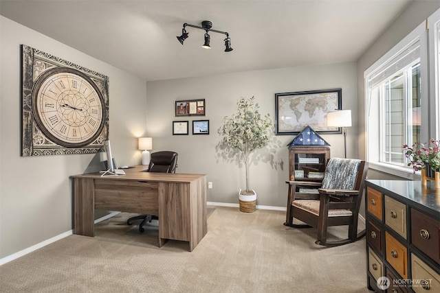 office featuring track lighting, light colored carpet, and baseboards