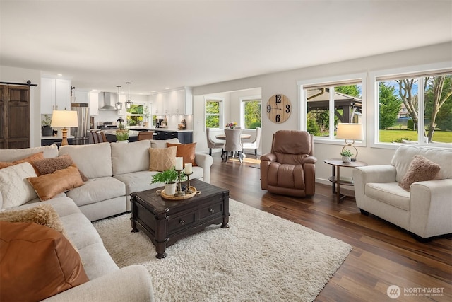 living area with recessed lighting, a barn door, and dark wood-type flooring