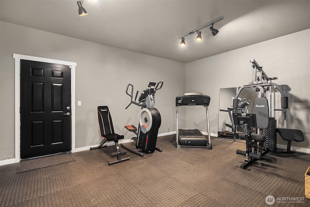 exercise area featuring rail lighting and baseboards