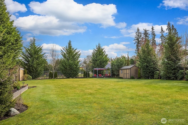 view of yard featuring an outbuilding, a storage shed, and fence