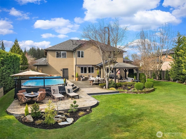 back of house with an outdoor living space, a fenced in pool, fence, a gazebo, and a lawn