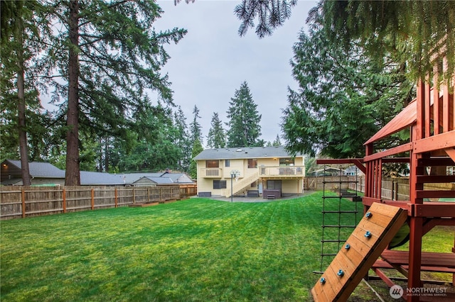 view of yard featuring stairway, a fenced backyard, and a playground