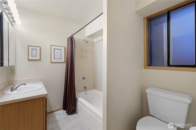 bathroom with vanity, shower / bath combination with curtain, toilet, and baseboards