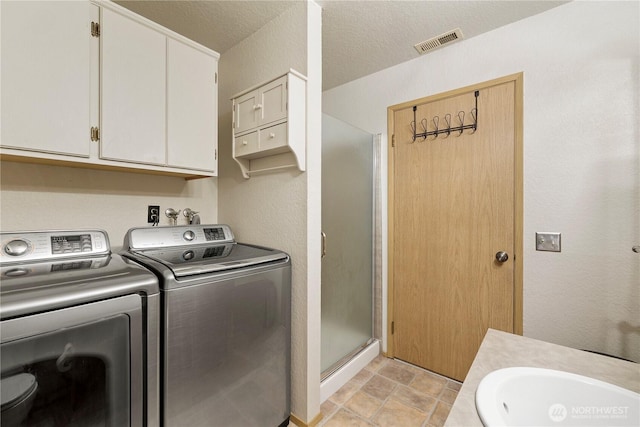 laundry room featuring visible vents, laundry area, independent washer and dryer, a textured ceiling, and a sink