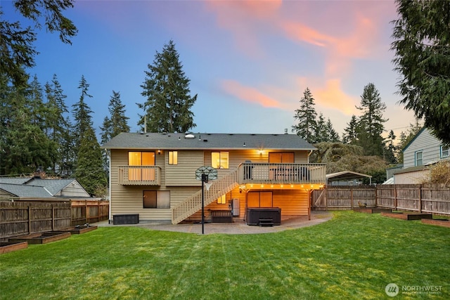 back of house at dusk with a hot tub, central AC, a yard, a fenced backyard, and a patio