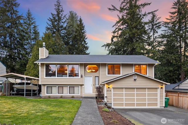 raised ranch featuring driveway, a front lawn, fence, a garage, and a chimney