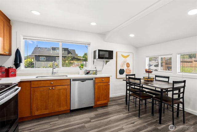 kitchen with brown cabinetry, recessed lighting, a sink, stainless steel appliances, and dark wood-type flooring