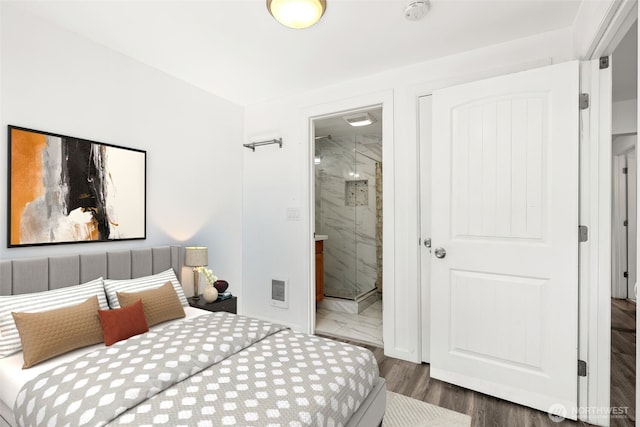 bedroom featuring visible vents, connected bathroom, and wood finished floors