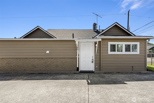 view of front of home with fence and a shingled roof