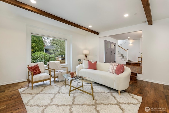 living room featuring beamed ceiling, baseboards, wood finished floors, and stairs