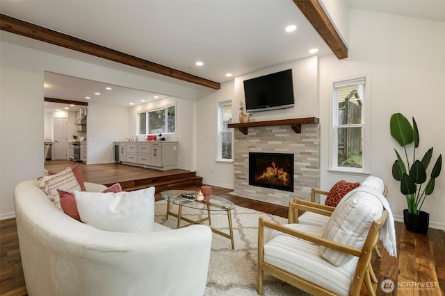 living room featuring baseboards, beamed ceiling, recessed lighting, a fireplace, and wood finished floors