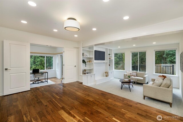 unfurnished living room with recessed lighting, baseboards, and wood finished floors