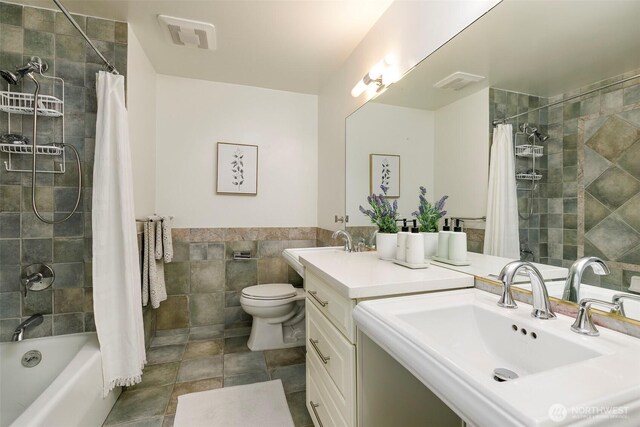 full bathroom featuring visible vents, toilet, tile walls, and shower / bath combo