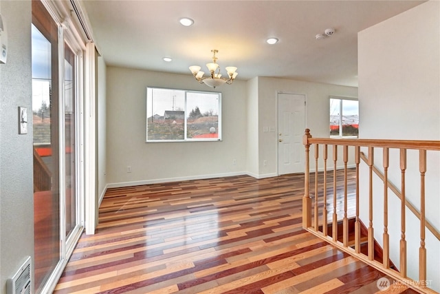 spare room featuring visible vents, baseboards, a chandelier, recessed lighting, and hardwood / wood-style flooring