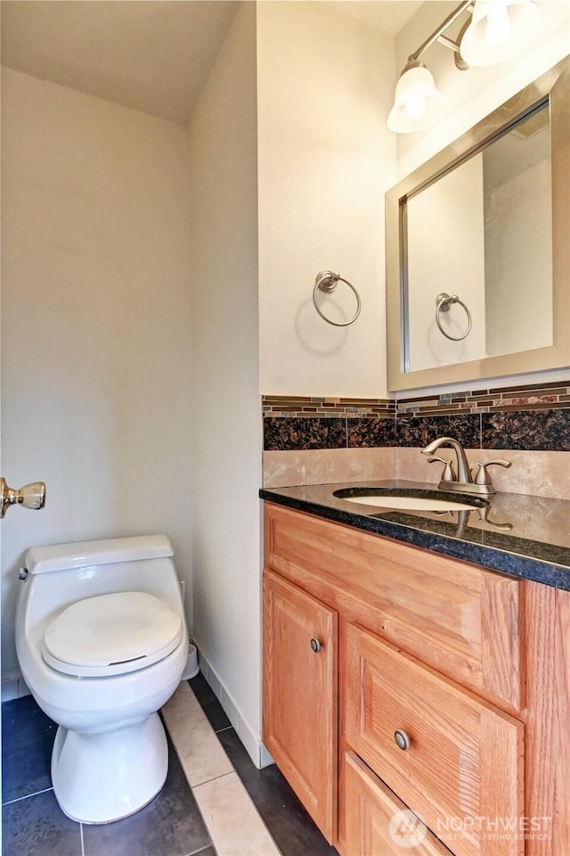 half bath with tile patterned flooring, toilet, and vanity