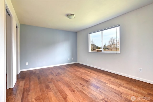 unfurnished room featuring baseboards and hardwood / wood-style floors