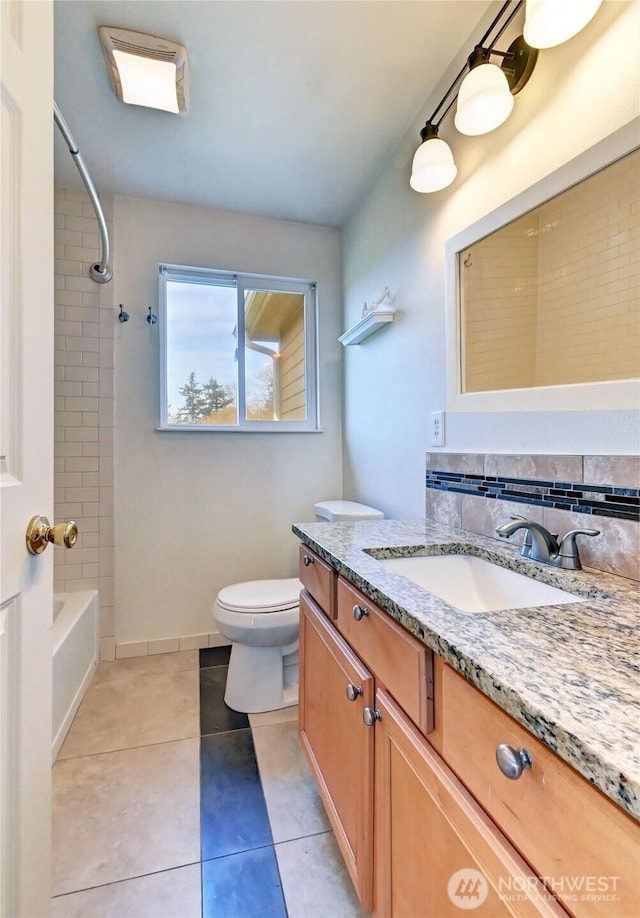 full bathroom featuring tile patterned floors, toilet, tasteful backsplash, bathtub / shower combination, and vanity