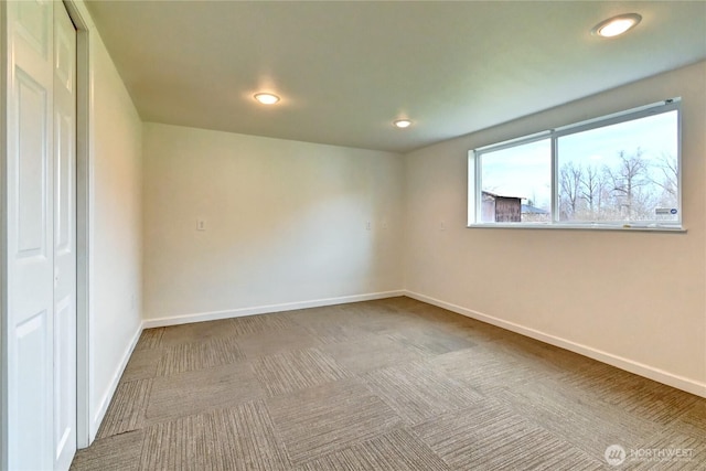 carpeted empty room featuring recessed lighting and baseboards