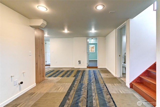 finished basement with stairs, baseboards, and wood finished floors