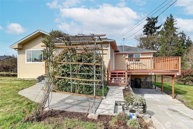 rear view of house with a lawn and a wooden deck