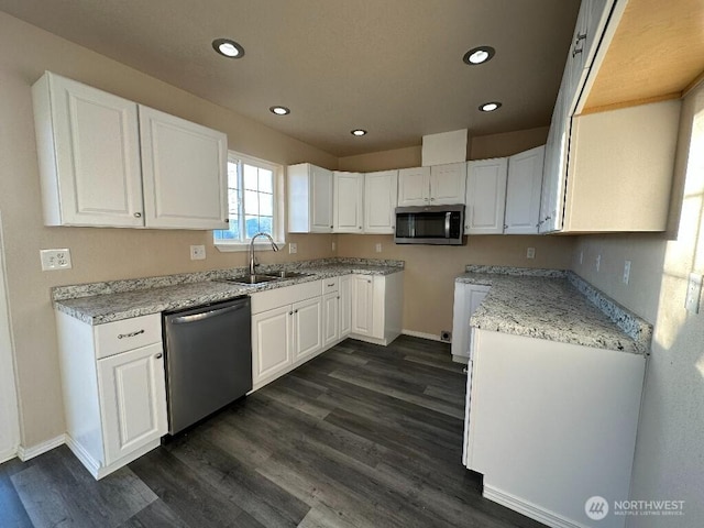 kitchen featuring a sink, dark wood-type flooring, appliances with stainless steel finishes, and white cabinets