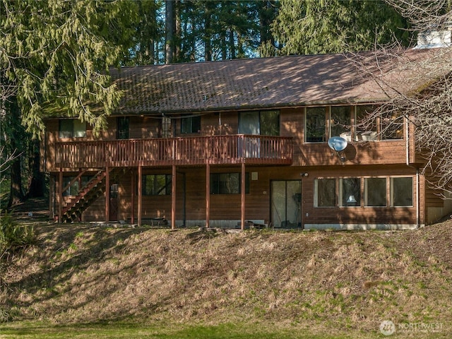 rear view of property featuring stairway and a deck