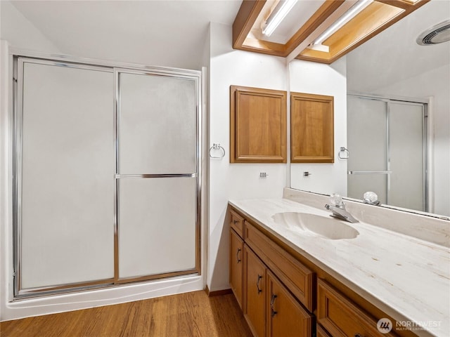 bathroom featuring vanity, a shower stall, wood finished floors, and visible vents