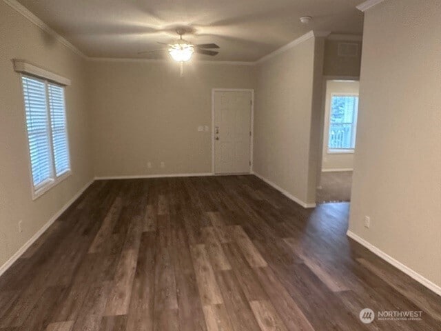 spare room with baseboards, dark wood-style floors, and crown molding