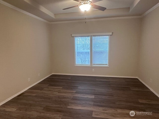 empty room featuring baseboards, a tray ceiling, ornamental molding, wood finished floors, and a ceiling fan