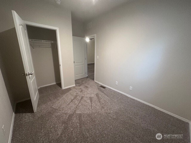 unfurnished bedroom with a closet, baseboards, and carpet