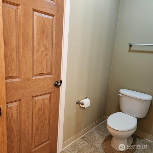 bathroom with tile patterned flooring, toilet, and baseboards