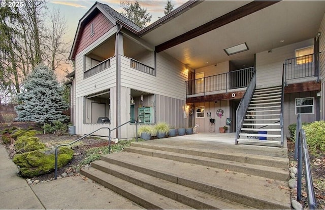 view of building exterior with central AC and stairs