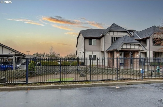 view of front of home with roof with shingles and fence