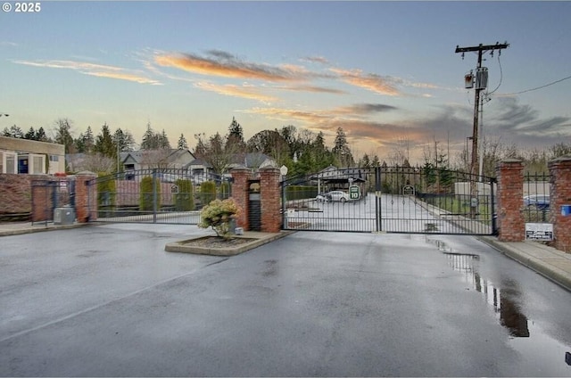 view of street with a gate, curbs, and a gated entry