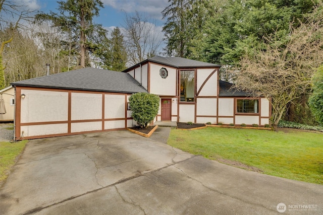 english style home featuring stucco siding, driveway, a shingled roof, and a front lawn