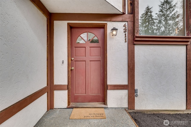 entrance to property featuring stucco siding