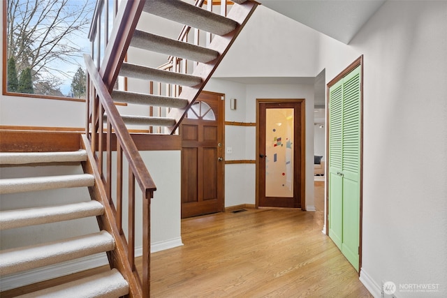 foyer featuring stairs, visible vents, baseboards, and light wood-type flooring