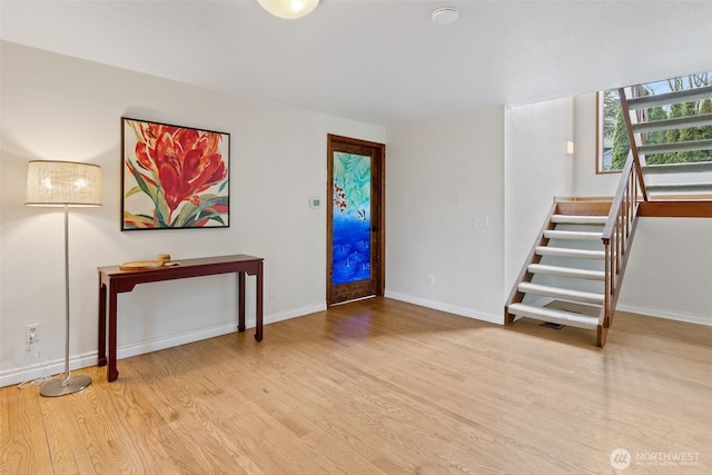 entrance foyer with stairs, baseboards, and light wood finished floors