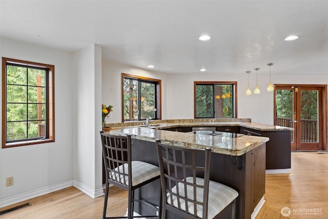 kitchen featuring recessed lighting, visible vents, light wood-type flooring, and light stone countertops