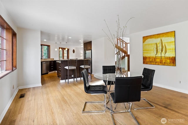 dining space featuring visible vents, plenty of natural light, and light wood finished floors