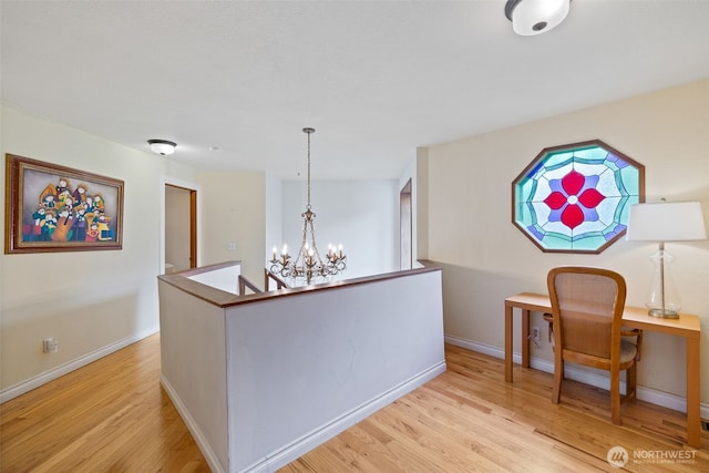 interior space featuring a notable chandelier, light wood-style floors, and baseboards