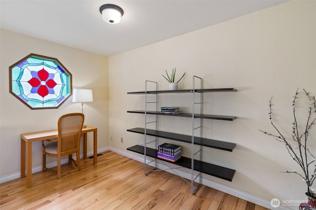 home office with baseboards and wood finished floors